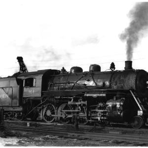 F-5 2-8-0 #164 (ex-CNE) at Waterbury, CT roundhouse in late 1940's. 3/4 view, engineer's side view.