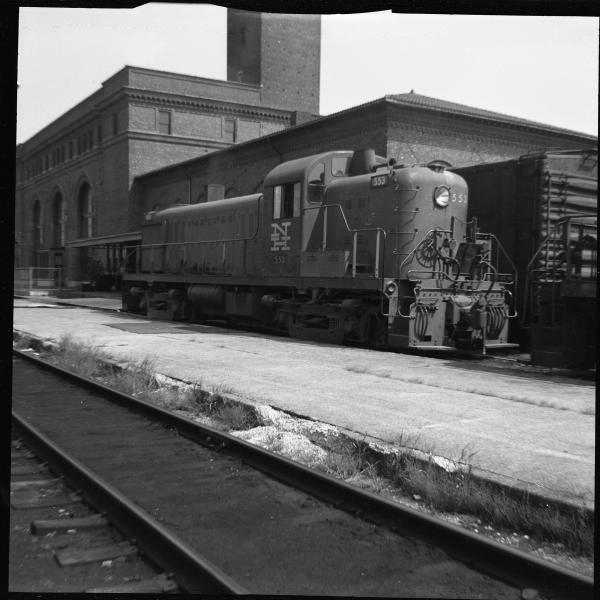 Left 3/4 rear view of RS-3 #553 in McGinnis Livery in front of passenger station