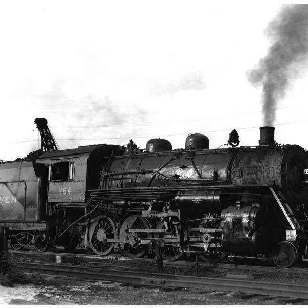 F-5 2-8-0 #164 (ex-CNE) at Waterbury, CT roundhouse in late 1940's. 3/4 view, engineer's side view.