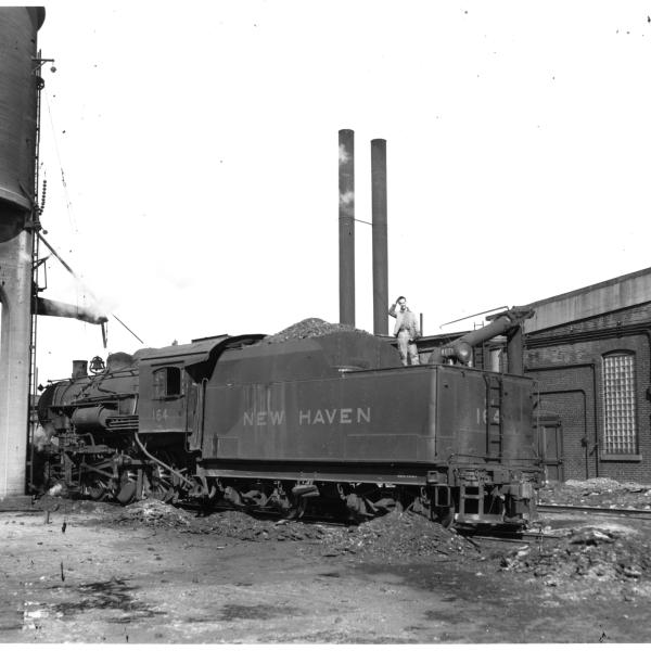 F-5 2-8-0 #164 (ex-CNE) at Waterbury, CT roundhouse, taking water.  3/4 view, fireman's side rear.