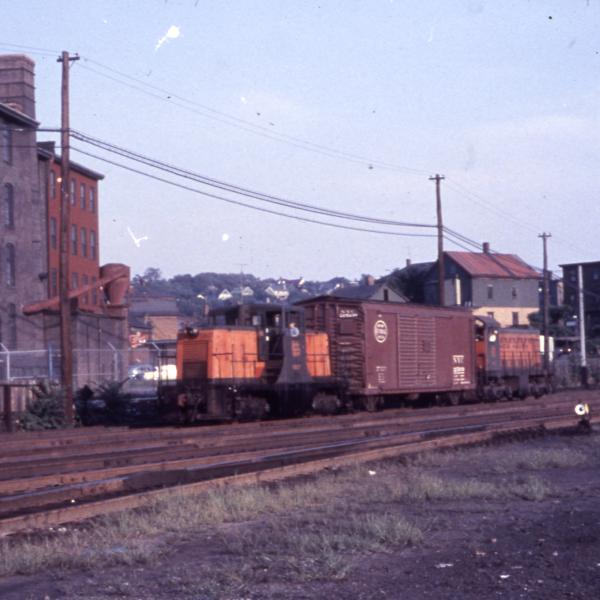 Distant photo of GE 44-tonner #0807 at Providence eastbound hump yard, Providence, RI.  Also in photo is unidentified S-1, NYC boxcar is between 0807 and the S-1