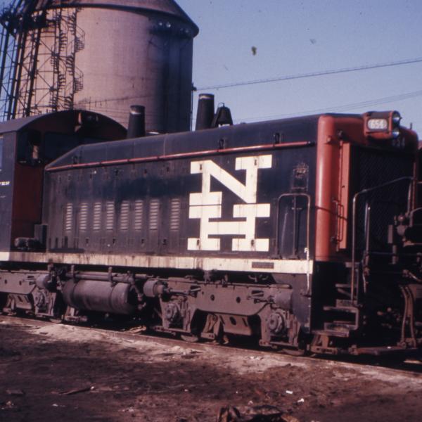 3/4 front view of the engineer's side of SW-1200 number 654 at Cedar Hill Yard with the coal tower in the background.
